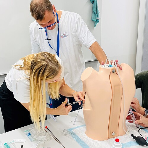 Eine Teilnehmerin des «Pediatric Emergency Medicine Bootcamps» legt eine Thoraxdrainage ein und wird dabei von einem Experten unterstützt. Bild: zvg